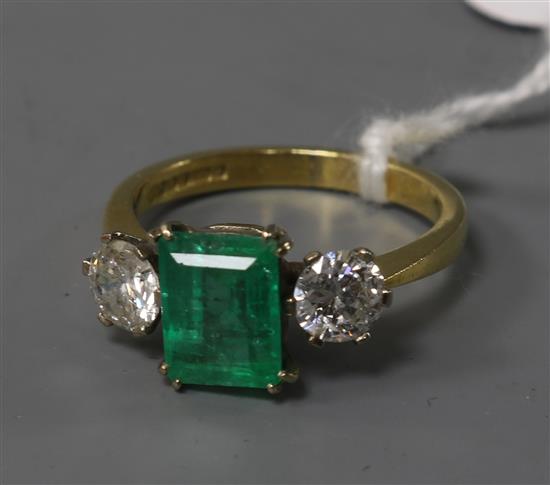 A modern 18ct gold, emerald and diamond three stone ring, size N/O